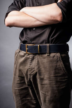 Black leather belt with ash buckle at mens waistの写真素材