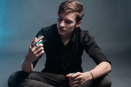 Sad man looks at an empty glass on a dark background