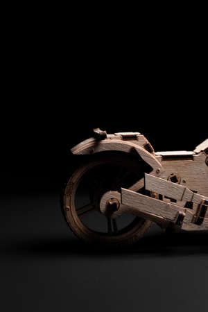 Wooden toy motorcycle on a black background a close upの写真素材