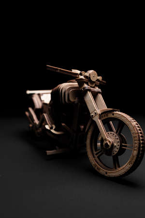 Wooden toy motorcycle on a black background a close upの写真素材