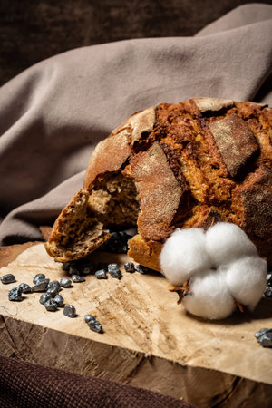 A piece of bitten bread next to a whole loaf on a wooden backgroundの写真素材