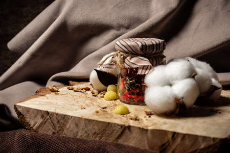 A jar with a beetle inside lies next to cotton on a wooden boardの写真素材