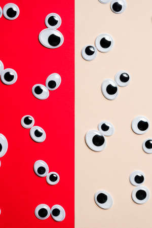 A bunch of toy eyes on an airtight two-color background split in halfの写真素材