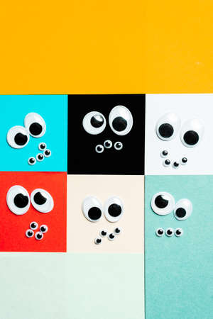 Smileys from toy eyes on hermetic multi-colored background