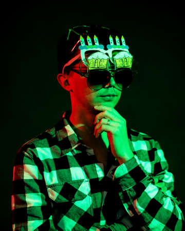 The guy with a few glasses is illuminated with green and red lightの写真素材