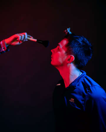 Emotions of a guy in a studio with blue and red light on a black background