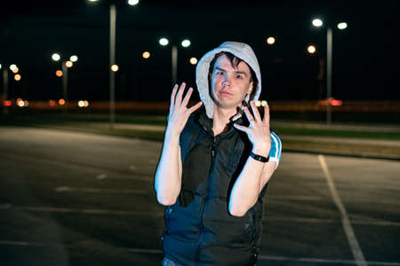 Guy at night in the parking lot against the background of lanternsの写真素材