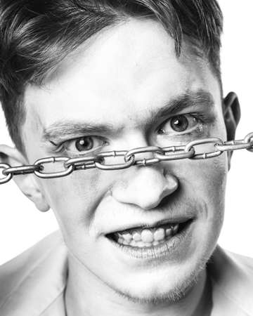 Black-and-white contrast portrait of an aggressive guy looking directly into the camera against a...