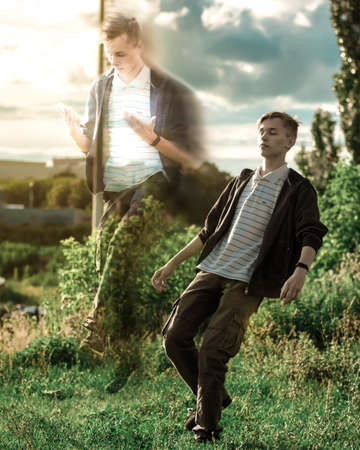 The soul flies out of the body of a young man against the background of sunsetの写真素材