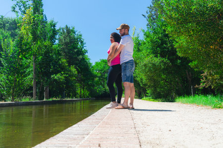 Young couple in love walking on a wooden pier in the park.の写真素材