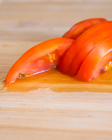 Sliced tomatoes on a wooden cutting board. Selective focus.の写真素材