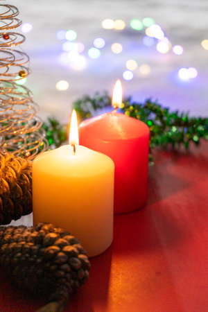 Christmas still life with burning candles and christmas decorations on red backgroundの写真素材