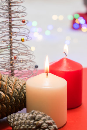 Christmas decoration with burning candles and Christmas tree on a red background.の写真素材