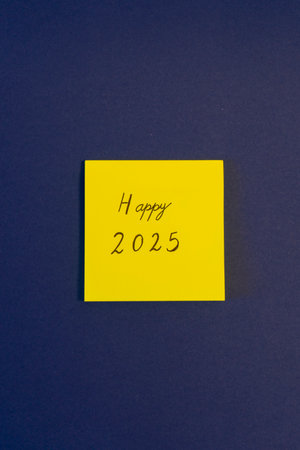 Happy new year written on yellow sticky note isolated on blue background.の写真素材