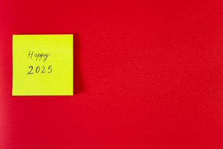 Happy new year text on yellow sticky note isolated on red background