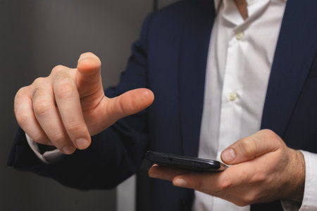Close-up of a businessman using a mobile phone in his officeの写真素材