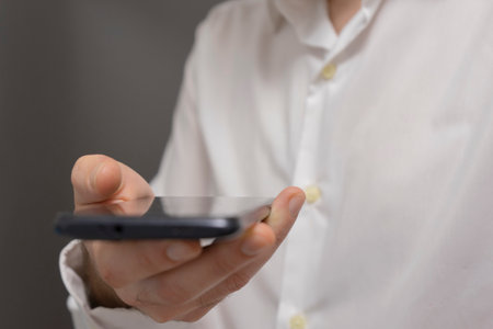 Closeup of a man using mobile smart phone with blank screen.の写真素材
