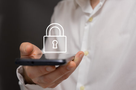 Man holding a smartphone with a padlock icon on the screen.の写真素材
