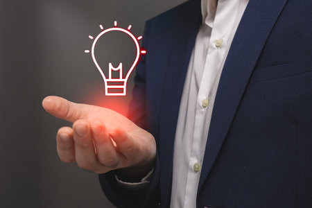 Businessman holding a glowing lightbulb in his hand. Business idea conceptの写真素材