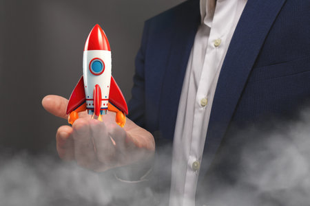 Businessman holding a rocket in his hand. Business success concept.の写真素材