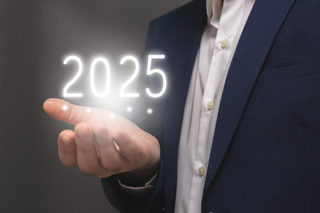 Businessman hand showing new year 2025 over gray background. New year conceptの写真素材