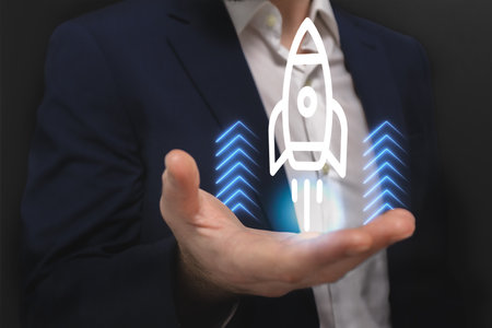 Businessman holding a rocket hologram over his hand. Startup conceptの写真素材
