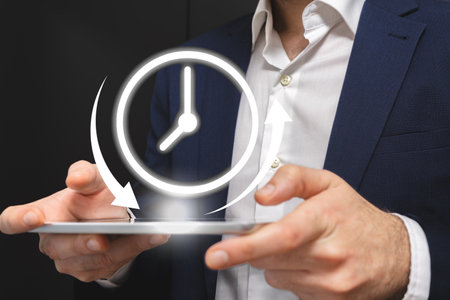 Time management concept. Businessman holding tablet with clock on screen.の写真素材