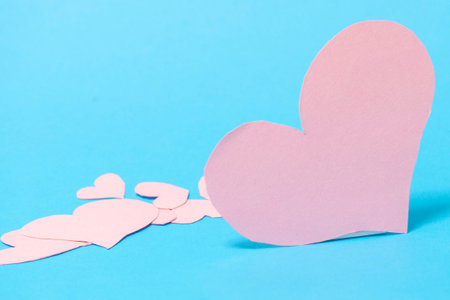 A big pink heart with smaller hearts on a blue background. Valentine's Day conceptの写真素材