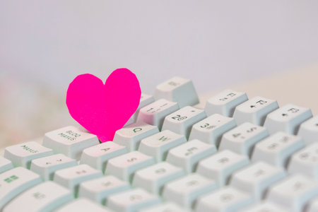Pink paper heart on computer keyboard, valentine's day conceptの写真素材