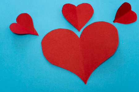 Red paper hearts on blue background. Valentine's day concept. Copy space.の写真素材