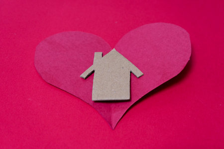 Paper heart with house symbol on red background. Love and family concept.の写真素材