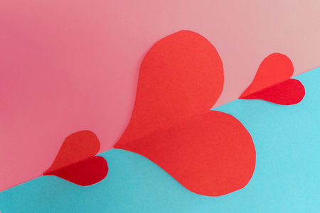 Red paper hearts on a blue and pink background. Valentines day concept.の写真素材