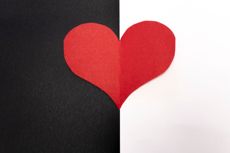 Red paper heart on black and white paper background. Valentine's day concept.の写真素材