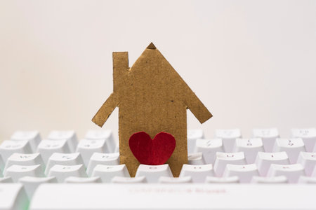 Paper house with red heart on white keyboard background. Concept of love for home, real estate, mortgage, loan, mortgage.の写真素材