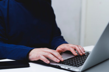 Close-up of male hands typing on laptop keyboard. Businessman working in officeの写真素材