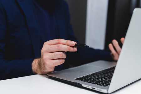 Cropped image of a person using a laptopの写真素材