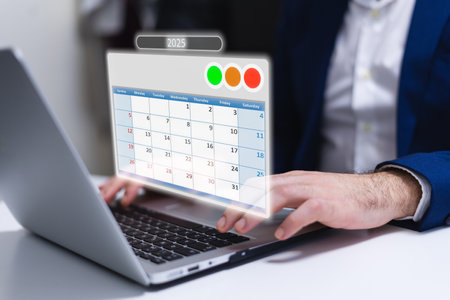 Businessman using a laptop with calendar app on the screen in officeの写真素材