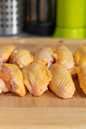 Raw chicken wings on a wooden cutting board. Close-up.の写真素材