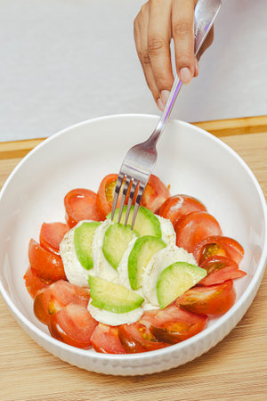 Tomatoes and cucumbers in a white bowl.の写真素材
