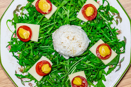 Salad with arugula, cheese and tomatoes on a white plateの写真素材