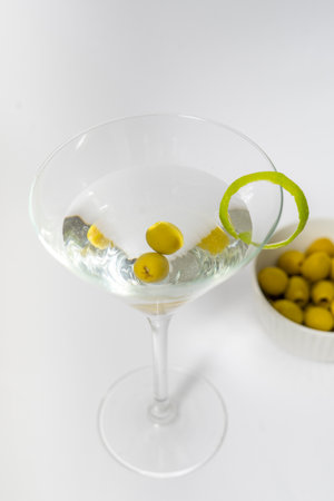 Martini cocktail with olives on white background. Alcoholic drinkの写真素材