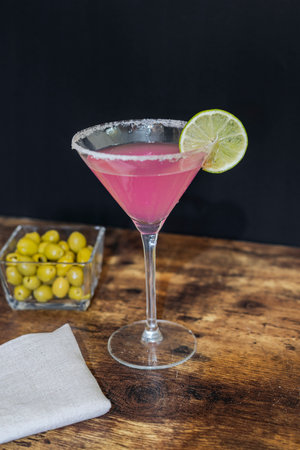 Cocktail with lime and olives on a wooden table.の写真素材