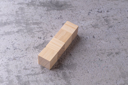 Wooden blocks stacked on top of each other on concrete background.