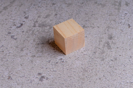 Wooden cube on concrete background. Copy space for your text.の写真素材