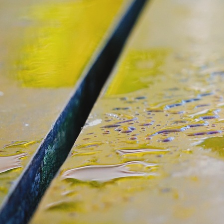 raindrops on the wooden bench in the streetの写真素材