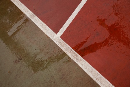 old green and red tennis court abandoned in the streetの写真素材