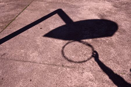 man playing basketball shadow silhouette on the ground in the streetの写真素材