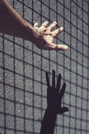 man hand shadow silhouette on the wallの写真素材