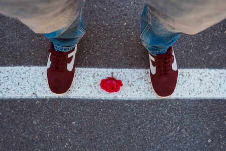 feet and sneakers on the ground in the street