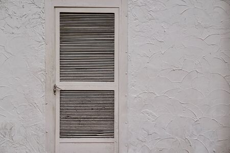 door on the white wall facade in the street